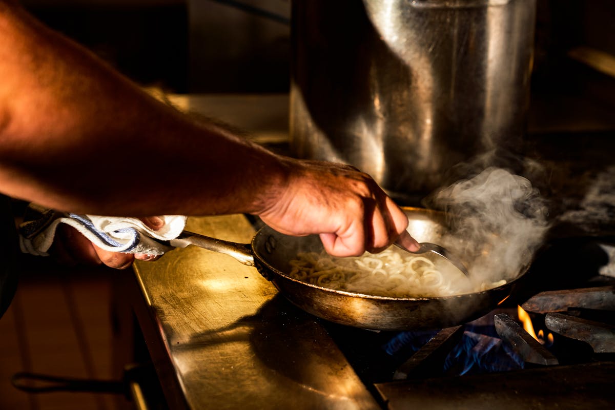 a man cooking food in a pan